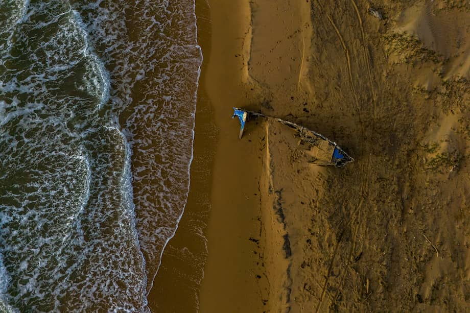 Restos de una embarcación quemada en la playa cerca de Puerto López, Colombia, el 21 de diciembre de 2025.