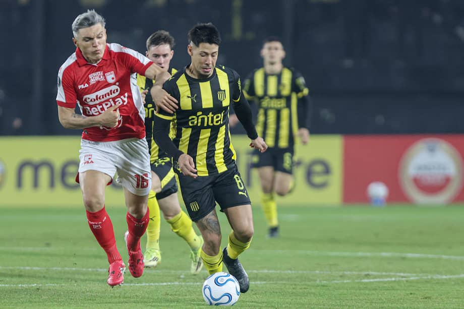 Roberto Nicolás Fernández de Peñarol disputa un balón con Daniel Torres de Santa Fe este miércoles 27 de mayo de 2026, en el último partido de fase de grupos de la Copa Libertadores en el estadio Campeón del Siglo de Montevideo, Uruguay.