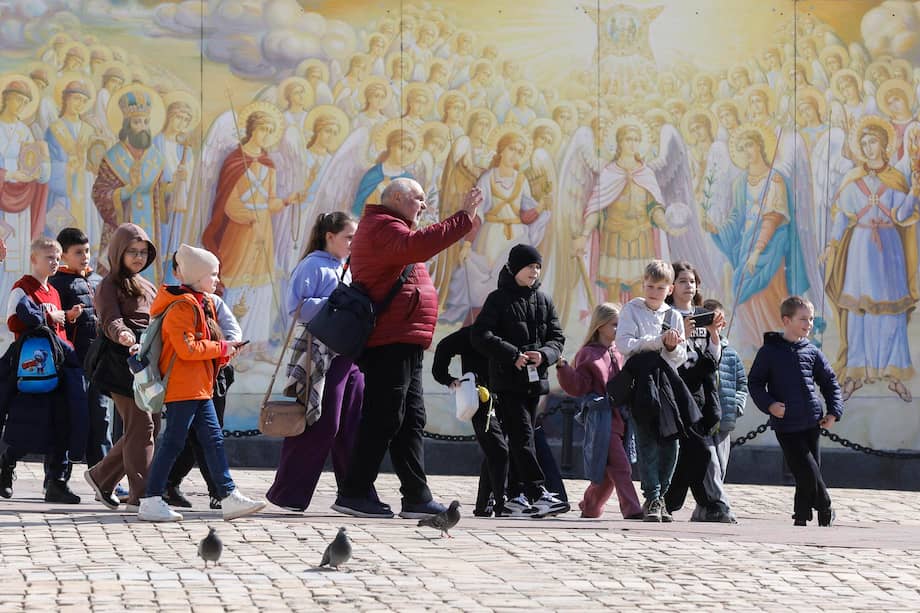 Niños ucranianos caminan junto a los frescos de la catedral de San Mykhailivsky en Kyiv.