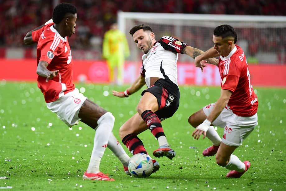Rafael Santos Borré de Internacional disputa el balón con Saúl Ñíguez de Flamengo en un partido por los octavos de final de la Copa Libertadores en el estadio Estadio Beira-Rio en Brasil.