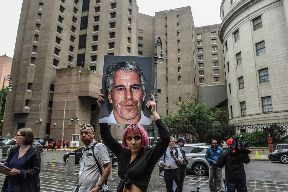 Un miembro de un grupo de protesta llamado "Hot Mess" sostiene un cartel de Jeffrey Epstein en Nueva York.
