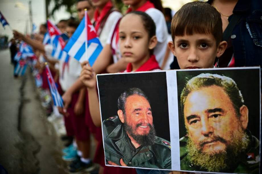 Un grupo de niños mientras esperaban el paso de las cenizas de Castro por Jimaguayú. / AFP
