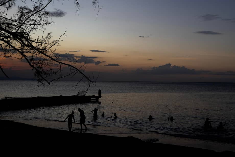 Personas disfrutan en una playa al atardecer en Montego Bay, Jamaica. / EFE/Orlando Barría
