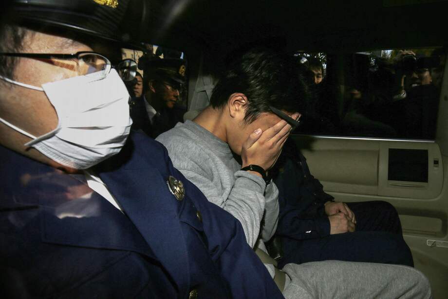 Esta foto de archivo, tomada el 1 de noviembre de 2017, muestra al sospechoso Takahiro Shiraishi (C) cubriéndose la cara con las manos mientras es trasladado a la oficina del fiscal desde una estación de policía en Tokio.