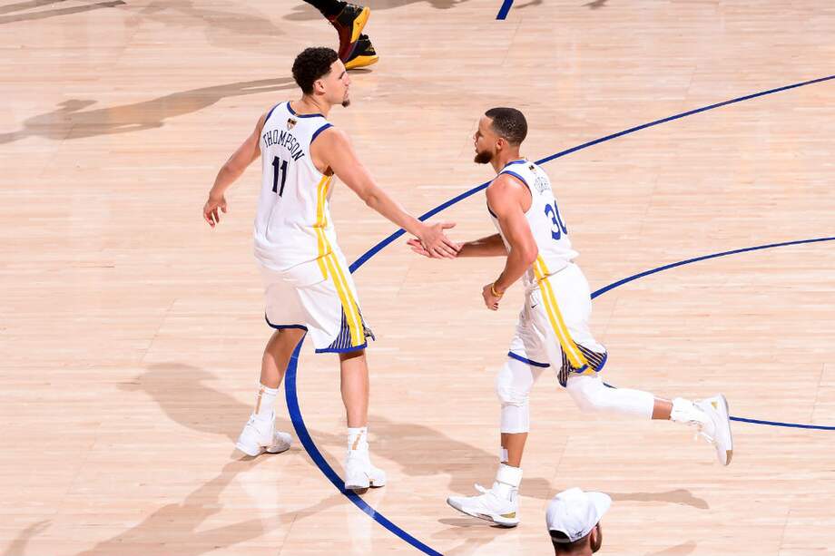 Curry celebra con Thompson uno de los puntos de los Warriors en tiempo extra contra los Cavaliers. / AFP