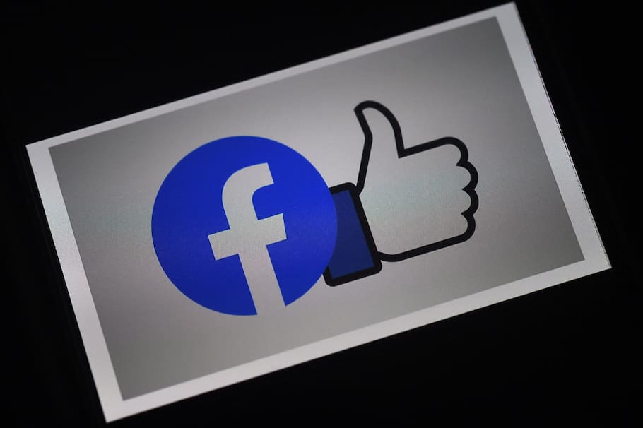 (FILES) This file photo illustration taken on March 25, 2020 shows a Facebook App logo displayed on a smartphone in Arlington, Virginia. - Facebook said on February 23, 2021 it will lift a contentious ban on Australian news pages "in the coming days", after the government agreed to amend a world-first media law fiercely opposed by the tech giant. (Photo by Olivier DOULIERY / AFP)