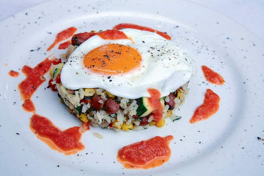 Huevo frito sobre arroz mexicano al wok con salsa de tomate