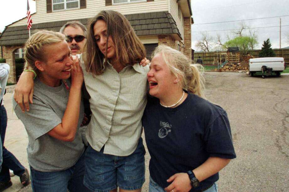 En esta foto tomada el 20 de abril de 1999, tres estudiantes de la escuela Secundaria de Columbine escapan de la tragedia luego de que dos jóvenes entraran a la institución y abrieran fuego contra los menores que se encontraban adentro. / AFP