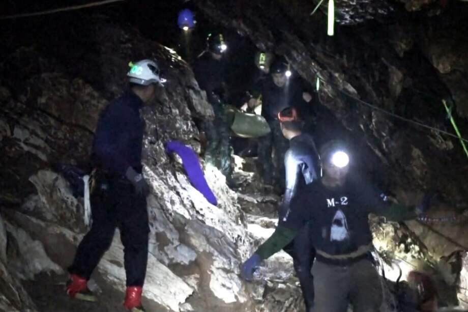 Varios miembros del equipo de rescate evacuan a un niño del equipo juvenil de fútbol atrapado en la cueva Tham Luang, en Chiang Rai (Tailandia). / EFE