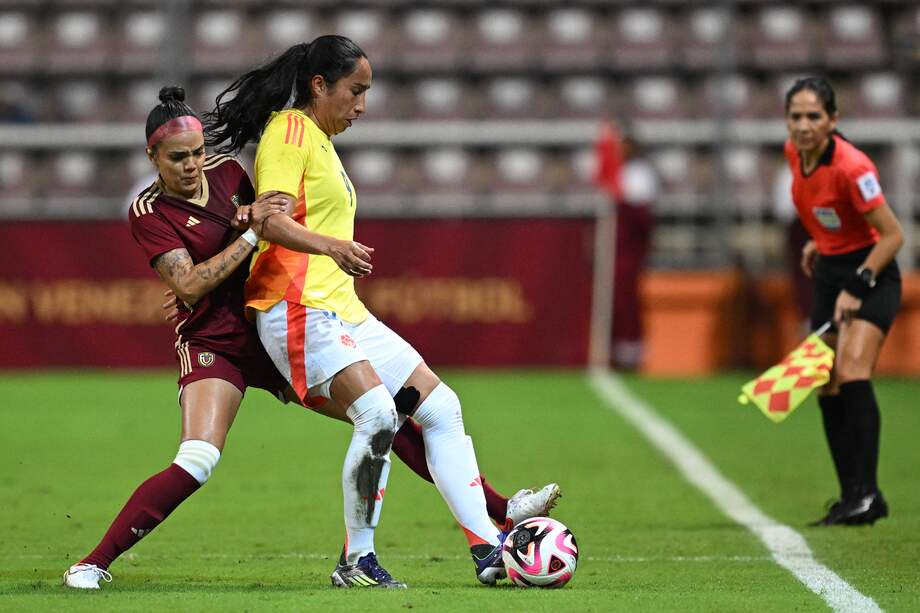 La venezolana María Peraza (i) y la colombiana Mayra Ramírez luchan por el balón durante el partido amistoso de fútbol femenino entre Venezuela y Colombia en el estadio Metropolitano de Barquisimeto, Venezuela, el 30 de mayo de 2024.