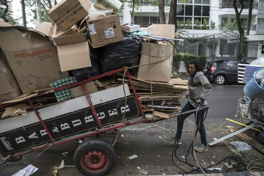 Maura Pereira, de 43 años, mientras recolecta basura en una calle de Sao Paulo (Brasil). / EFE