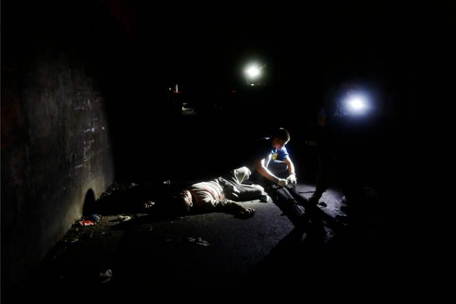 Integrantes de la Policía Nacional de Filipinas (PNP) investigan en una escena con el cuerpo de una persona asesinada durante un operativo contra drogas ilegales en Manila. / EFE
