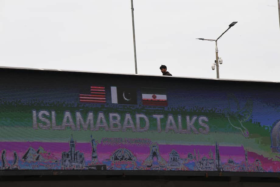 Un hombre pasa junto a una valla publicitaria cerca del centro de prensa mientras delegaciones de Estados Unidos e Irán inician conversaciones de paz en Islamabad, Pakistán, el 11 de abril de 2026.