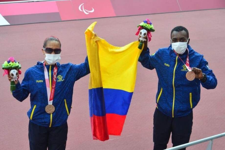 Angie Pabón con su guía Luis Arizala sosteniendo la medalla de bronce en los Juegos Paralímpicos.