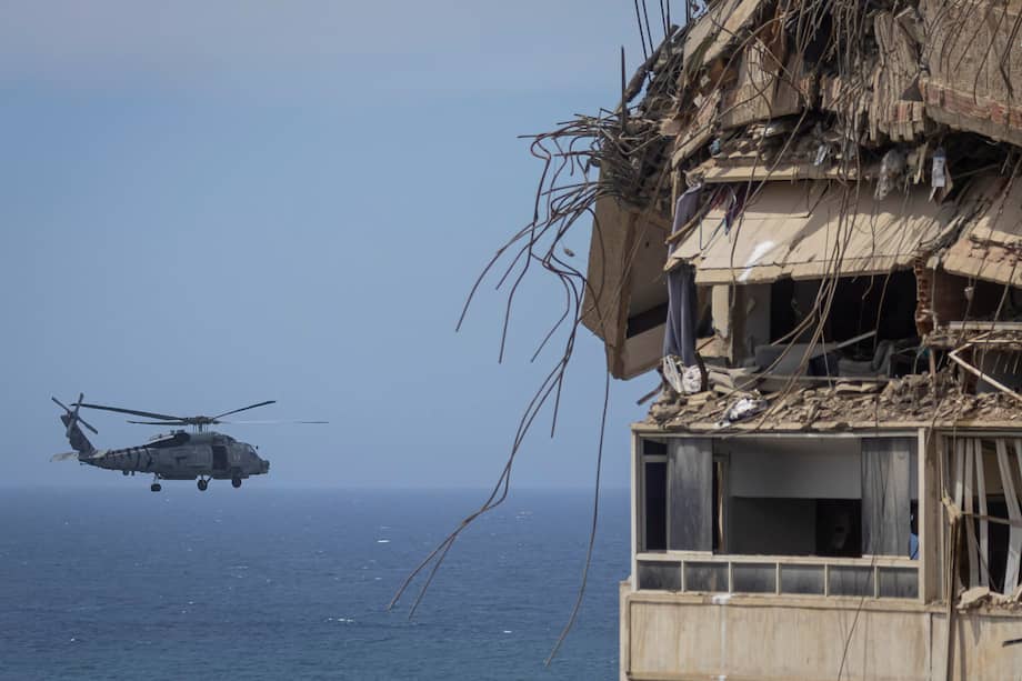 Fotografía de un helicóptero norteamericano sobrevolando el mar caribe frente a edificios destruidos por los terremotos en Venezuela, en Catia La Mar, La Guaira (Venezuela).