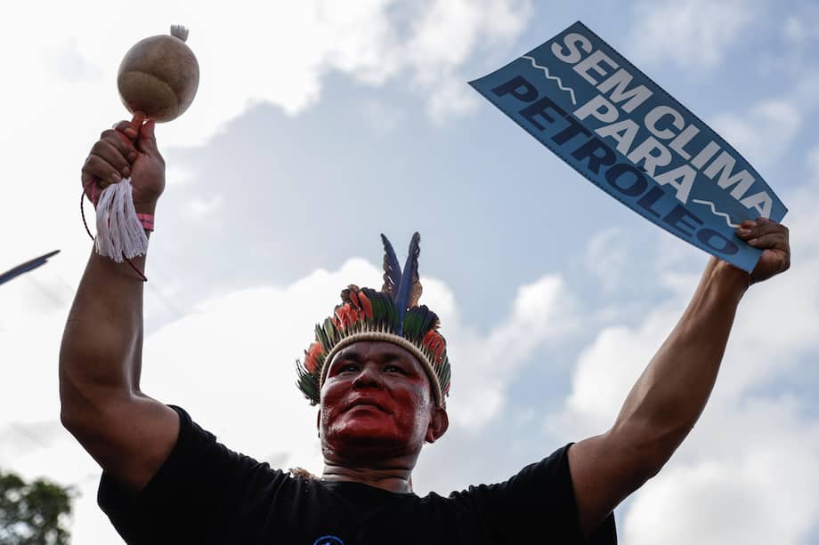 Un indígena sostiene un cartel durante la Marcha Global por el Clima ‘La Respuesta Somos Nosotros’ este lunes, en la Aldea COP30, en Belém (Brasil).