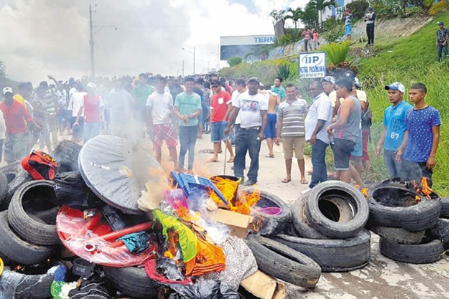 Residents of the Brazilian border town of Pacaraima burn tyres and belongings of Venezuelans immigrants after attacking their two main makeshift camps, leading them to cross the border back into their home country on August 18, 2018. Brazil will send troops to its border with Venezuela on Monday after residents of Pacaraima drove out Venezuelan immigrants from their improvised camps, amid growing regional tensions. Tens of thousands of Venezuelans have crossed the border into Brazil over the past three years as they seek to escape the economic, political and social crisis gripping their country. / AFP / Isac DANTES
