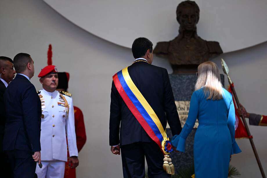 Nicolás Maduro y su esposa, Cilia Flores, dejan el Capitolio después de la juramentación, que hicieron sin mostrar las actas, que confirmarían el triunfo. (Photo by Juan BARRETO / AFP)