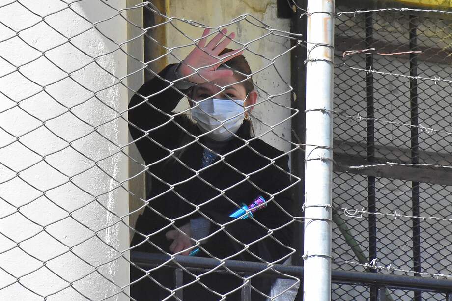AME5427. LA PAZ (BOLIVIA), 08/06/2022.- La expresidenta interina de Bolivia Jeanine Áñez saluda desde la cárcel de Mujeres de Miraflores, donde está en detención preventiva desde hace más de un año, hoy en La Paz (Bolivia). Áñez enfrenta un juicio por el caso llamado "golpe de Estado II", referido a sus acciones cuando era segunda vicepresidenta del Senado para asumir en 2019 la Presidencia de forma supuestamente irregular, según el oficialismo, tras las renuncias del entonces presidente Evo Morales y de toda la línea de sucesión presidencial. EFE/STRINGER