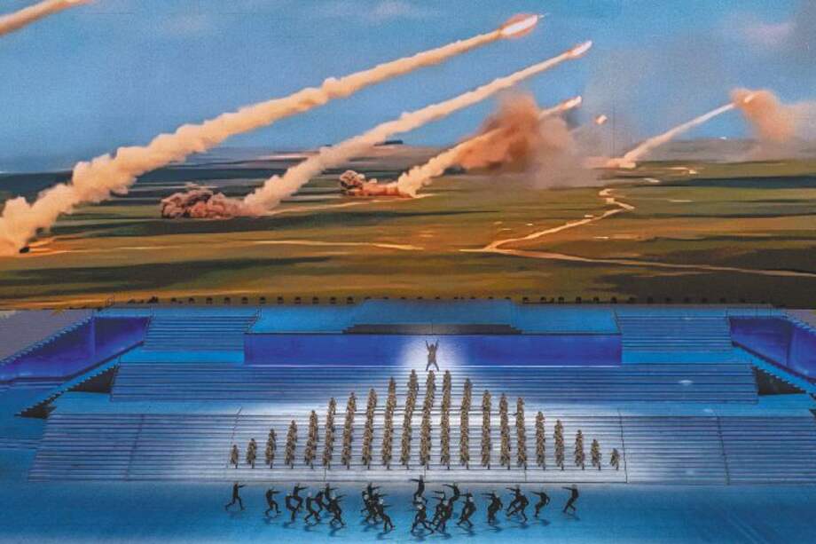 Artistas vestidos como militares actúan frente a una pantalla que muestra el lanzamiento de cohetes durante una gala masiva que marca el 100 aniversario del Partido Comunista el 28 de junio de 2021, en el estadio Olympic Bird's Nest en Beijing, China.
