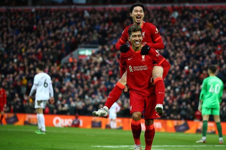 Takumi Minamino celebra con Roberto Firmino uno de los goles en la victoria del Liverpool sobre Brentford.