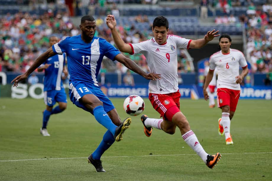Raúl Jiménez lucha el balón con Olivier Thomert de Martinica. / AFP