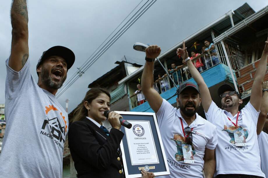El presidente de Nación DownHill, Javier García (i), el director ejecutigo de PXSports, Alejandro Mercado (c-d), Óscar Mecado (d) y la adjudicadora oficial de Guinness World Records, Natalia Ramírez Talero (c-i), posan con el certificado del récord Guinness entregado al Downhill Challenge como la carrera de ciclismo en downhill urbano más larga del mundo. / EFE