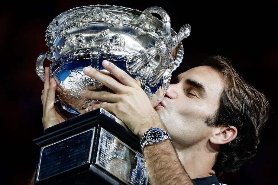 Roger Federer besa el trofeo del Abierto de Australia. / AFP