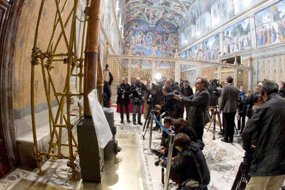 Reporteros gráficos toman fotos de las estufas dentro de la Capilla Sixtina del Vaticano.