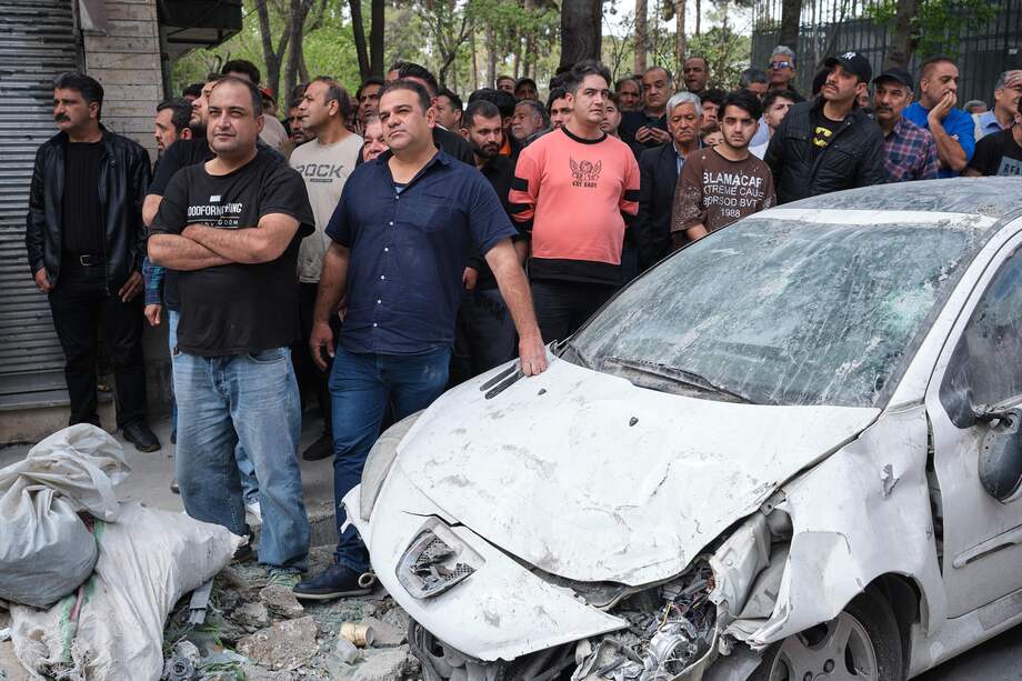 Un grupo de personas en las inmediaciones de la calle Rajaei del sureño barrio de 13 de Aban que fue atacado en la madrugada por Estados Unidos e Israel donde trabajaban desescombrando.