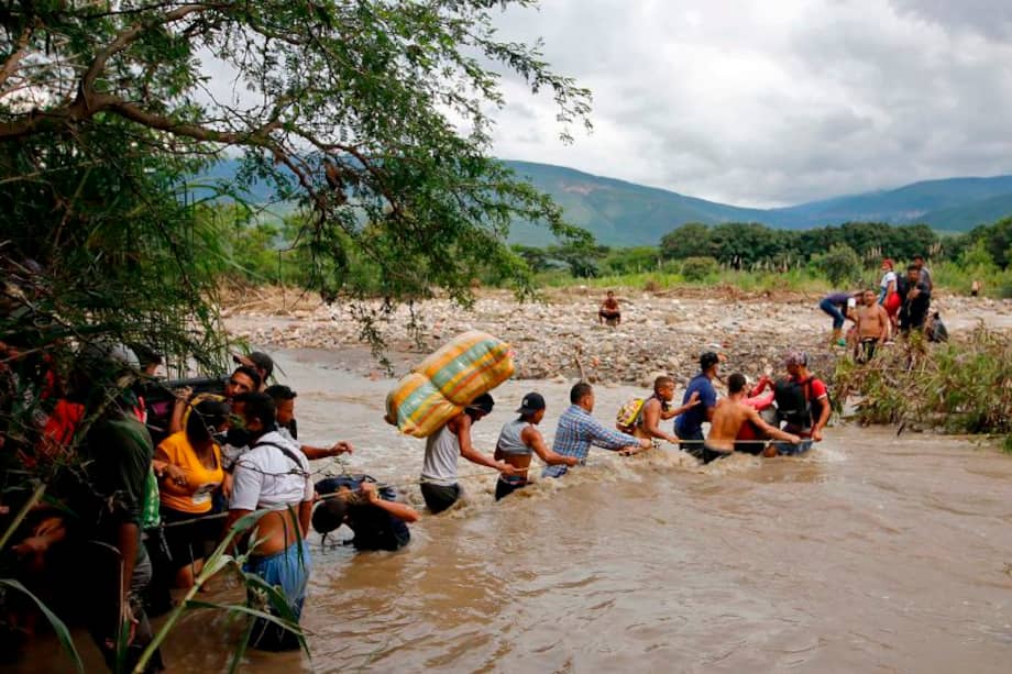 Migrantes venezolanos cruzaron el río Táchira, en la frontera con Colombia, para dejar su país; usan esta vía por cuenta del cierre del paso fronterizo. / AFP