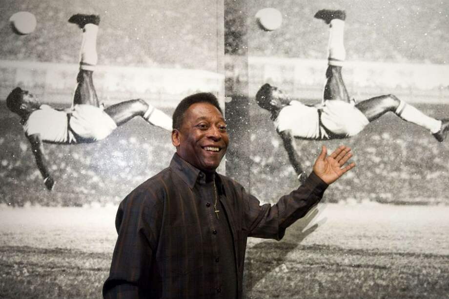 Pelé posa frente a unas fotografías de una pintura llamada: "Pele, Bicycle Kick". Foto: AFP
