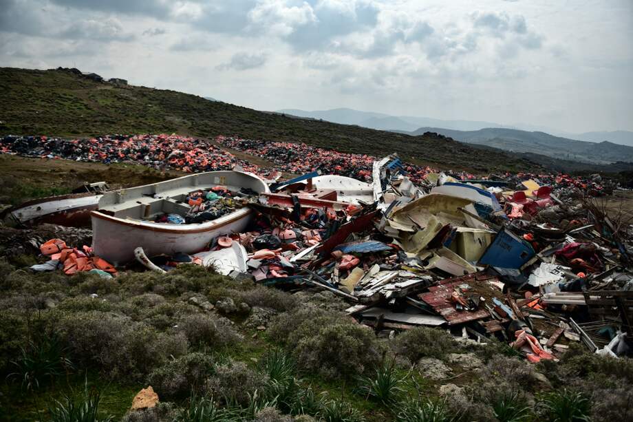 Un bote desastrado y chalecos en la costa de la isla de Lesbos (Grecia), luego de que decenas de migrantes arribaran. / AFP