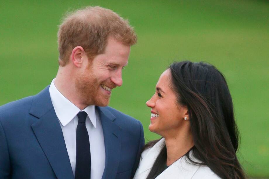 TOPSHOT - Britain's Prince Harry and his fiancée US actress Meghan Markle pose for a photograph in the Sunken Garden at Kensington Palace in west London on November 27, 2017, following the announcement of their engagement. Britain's Prince Harry will marry his US actress girlfriend Meghan Markle early next year after the couple became engaged earlier this month, Clarence House announced on Monday. / AFP / Daniel LEAL-OLIVAS