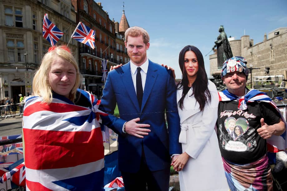 Dos turistas se fotografían junto a una imagen a tamaño real de la pareja de novios, el príncipe Harry y la estadounidense Meghan Markle, en Windsor (Reino Unido). / EFE