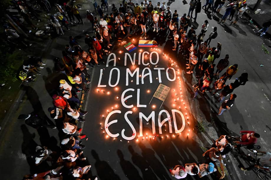 Familiares y amigos de Nicolás Guerrero, quien fue asesinado durante enfrentamientos con la policía antidisturbios en una protesta, se reúnen alrededor de velas y las palabras "Nico fue asesinado por ESMAD" ("Escuadrón Móvil Antidisturbios", durante una vigilia en su honor, en Cali.