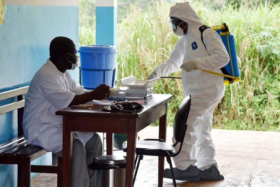 Médicos y enfermeras son desinfectados después de tratar a personas contagiadas con el ébola. / AFP