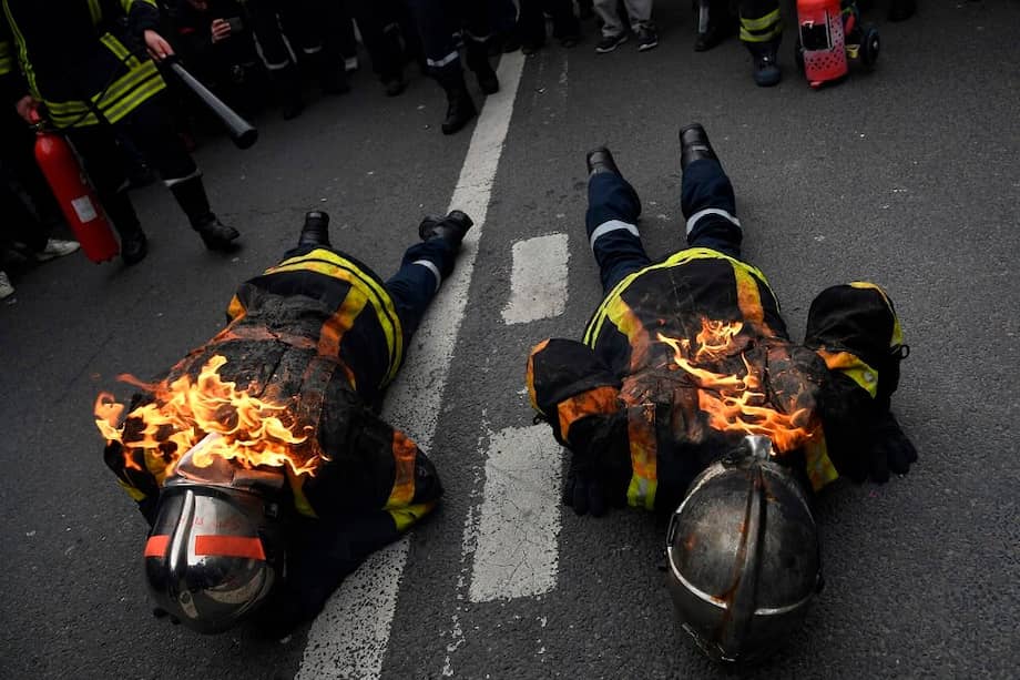 Durante la manifestación, algunos bomberos prendieron fuego a sus trajes en señal de protesta por la mejora de su equipamiento. / AFP
