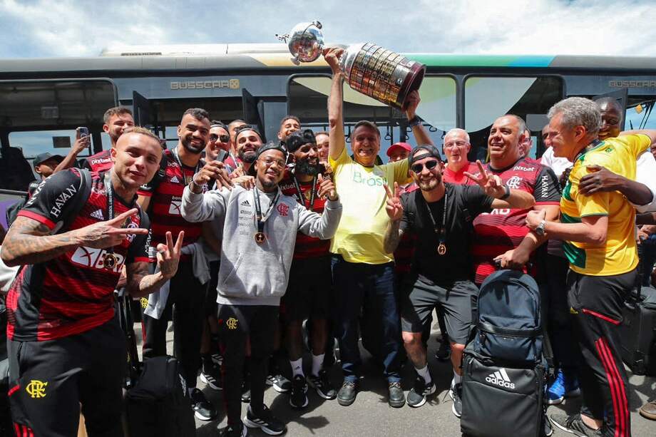 Foto publicada por el PL que muestra al presidente brasileño y candidato a la reelección Jair Bolsonaro (centro) levantando la Copa Libertadores al dar la bienvenida a los miembros del equipo brasileño Flamengo a su llegada al aeropuerto de Galeao en Río de Janeiro un día después de que ganaron el torneo de fútbol final en la ciudad ecuatoriana de Guayaquil, después de que votó en la segunda vuelta de las elecciones presidenciales el 30 de octubre de 2022.