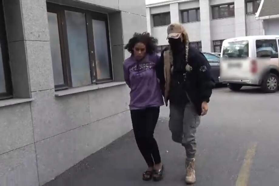 Esta foto muestra a una policía deteniendo a una mujer sospechosa de participar en la explosión mortal en una calle turística de Estambul, Turquía.