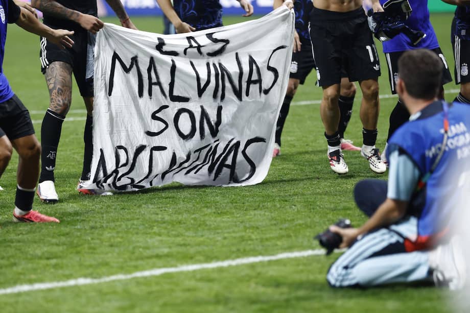 Los jugadores de Argentina sostienen una pancarta que dice "Las Islas Malvinas son argentinas" mientras celebran su victoria en la Copa Mundial de la FIFA.