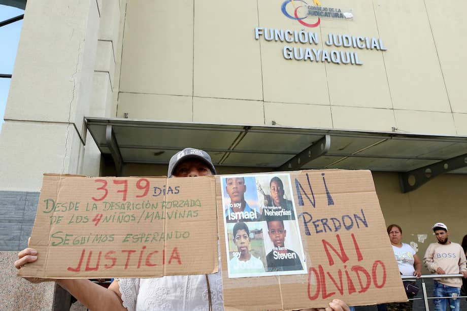 Una mujer sostiene carteles durante una manifestación este lunes, frente al Complejo Judicial de Guayaquil, en Guayaquil (Ecuador).