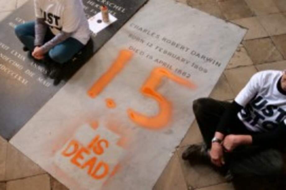 Una fotografía tomada y difundida por el grupo de campaña climática Just Stop Oil el 13 de enero de 2025 muestra a dos activistas, sentados en el suelo junto a la tumba de Charles Darwin, después de haber pintado sobre ella la frase "1,5 ha muerto" en protesta contra el cambio climático en acción, dentro de la Abadía de Westminster en el centro de Londres.