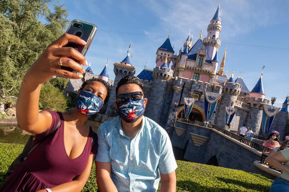 Fotografía cedida por Disneyland Resort donde una pareja se toma una selfie en frente del palacio de la Bella Durmiente en Disneyland Park en Anaheim, California.