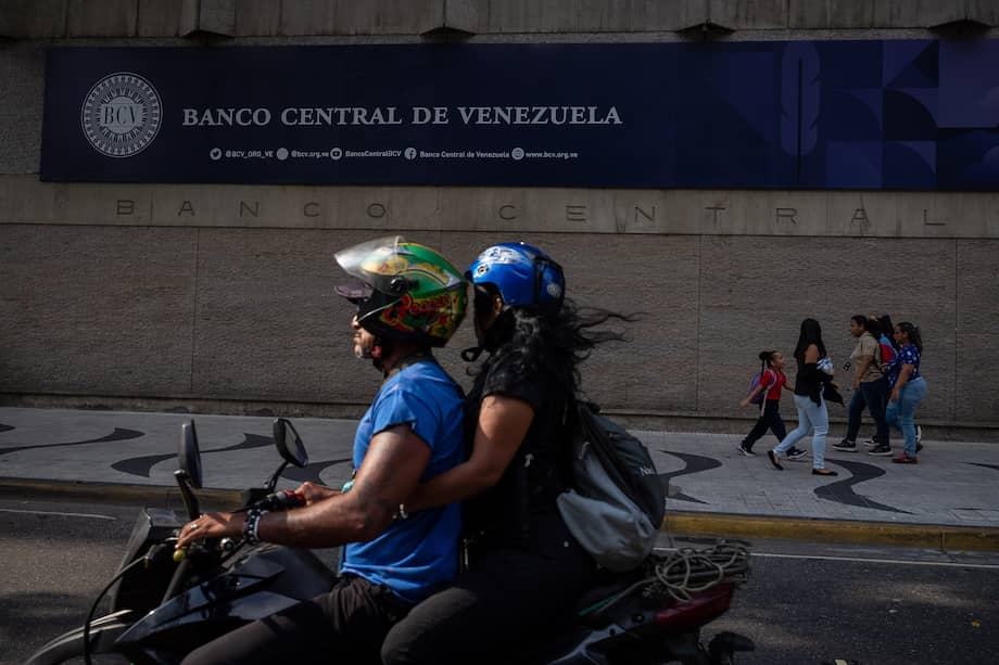 Personas transitan frente a la sede del Banco Central de Venezuela (BCV).