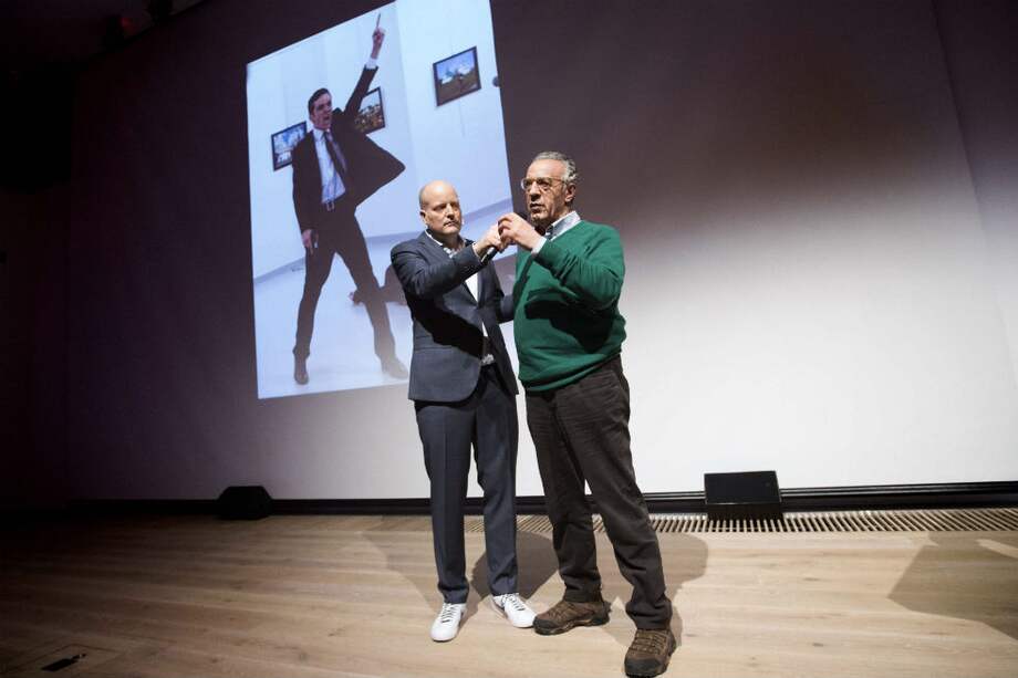 Burhan Ozbilici, el fotógrafo ganador del World Press Photo, y la imagen ganadora durante la recepción del premio. / AFP