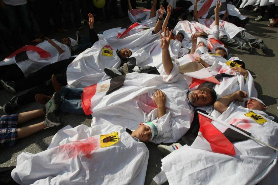 Manifestantes hacen el "signo Rabia" con sus manos en Ankara para protestar contra los asesinatos en masa en Siria y Egipto.