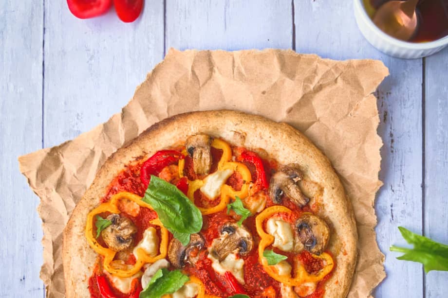 Los champiñones, los pimentones de colores y la albahaca fresca van muy bien con esta pizza.