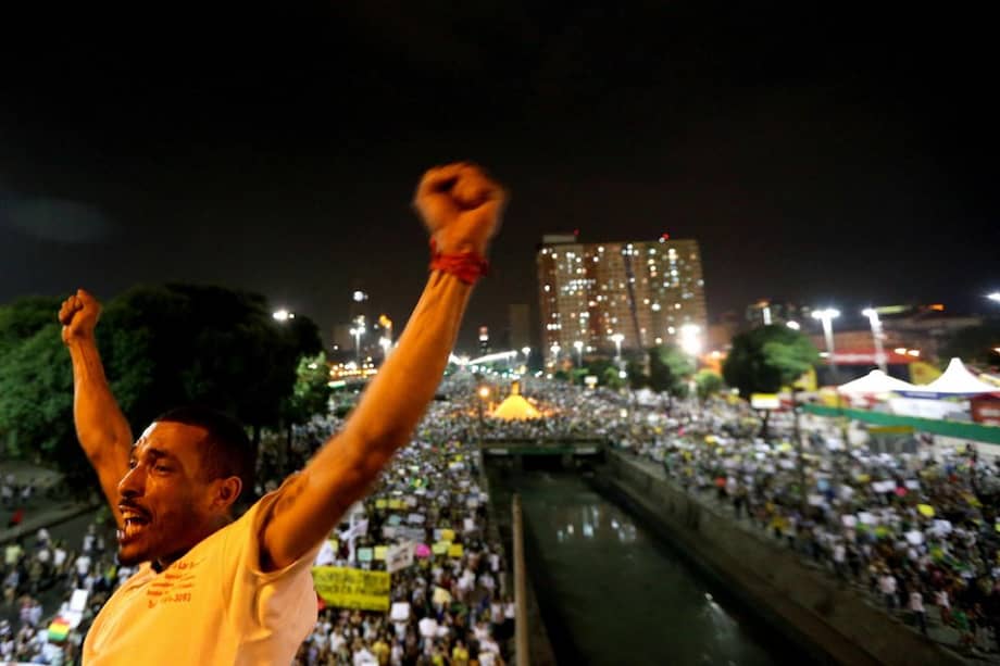 Un manifestante levanta las manos durante la multitudinaria protesta para exigir mejores servicios públicos en Río de Janeiro./ EFE