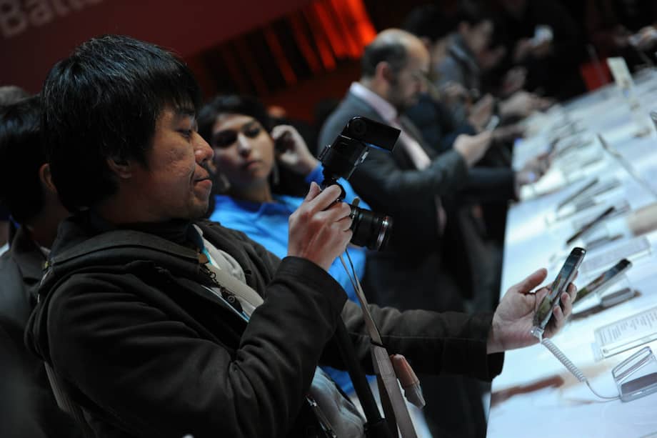 Uno de los asistentes al Radio City Music Hall, de Nueva York, toma una foto del nuevo Galaxy S4 durante su lanzamiento. / AFP